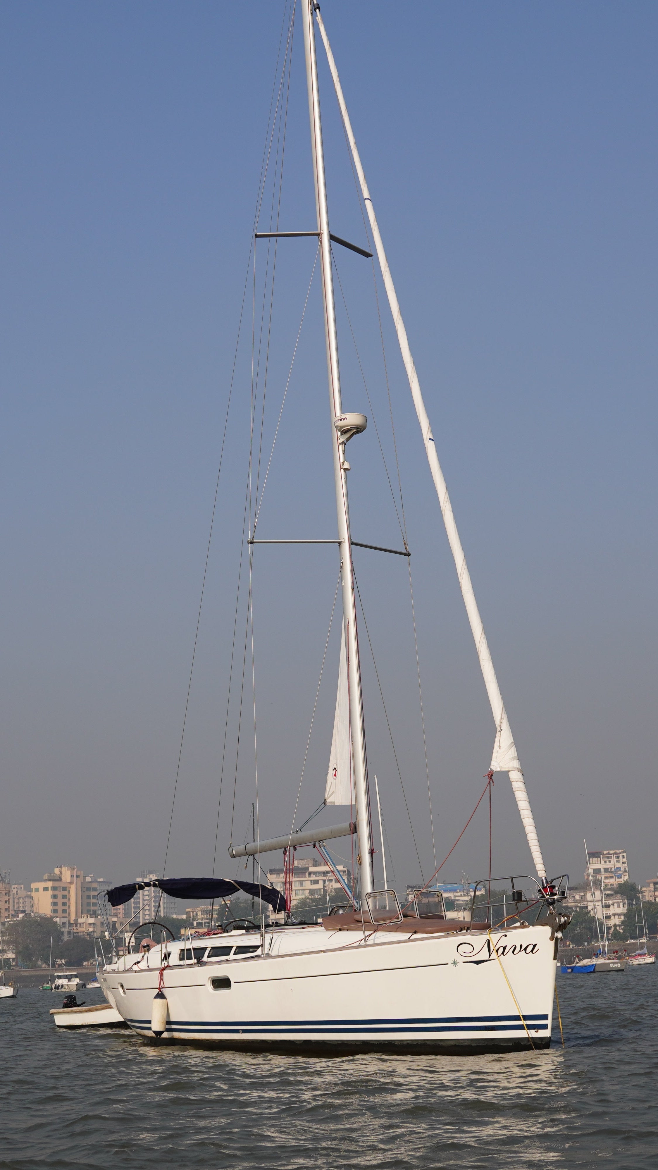 Sailing boat on a body of water with a city skyline in the background